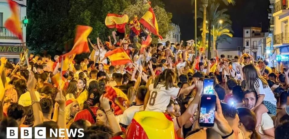 Crowd celebrating with flags in night street