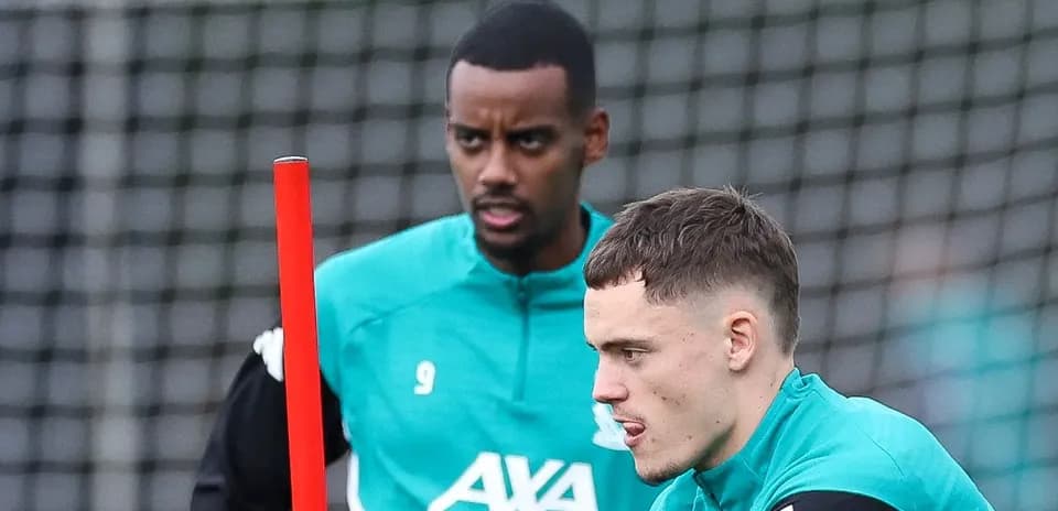 Two players training with equipment on the pitch