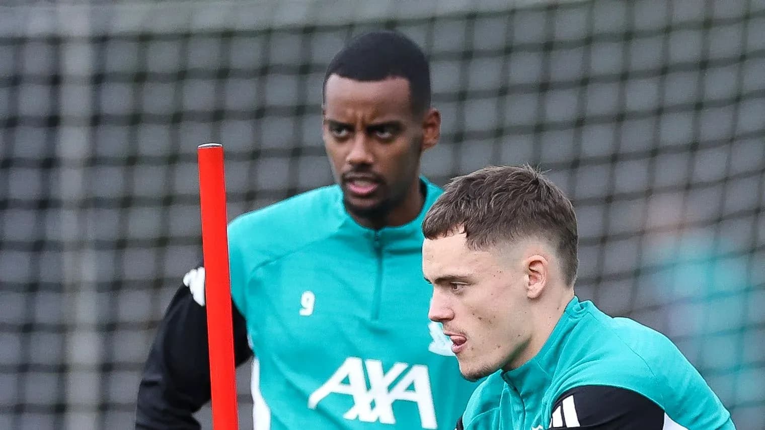 Two players training with equipment on the pitch