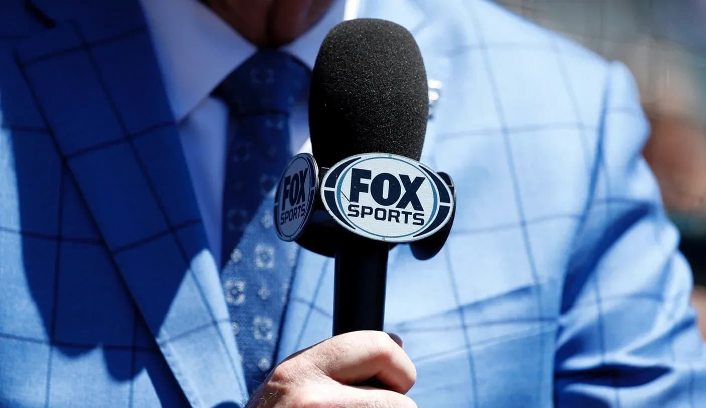 Microphone with FOX Sports logo held by person