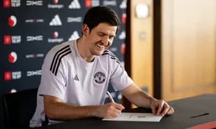 Player signing contract at press conference table