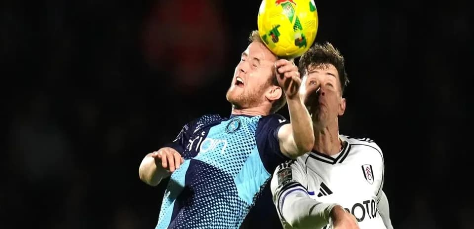 Two players contesting a header during football match