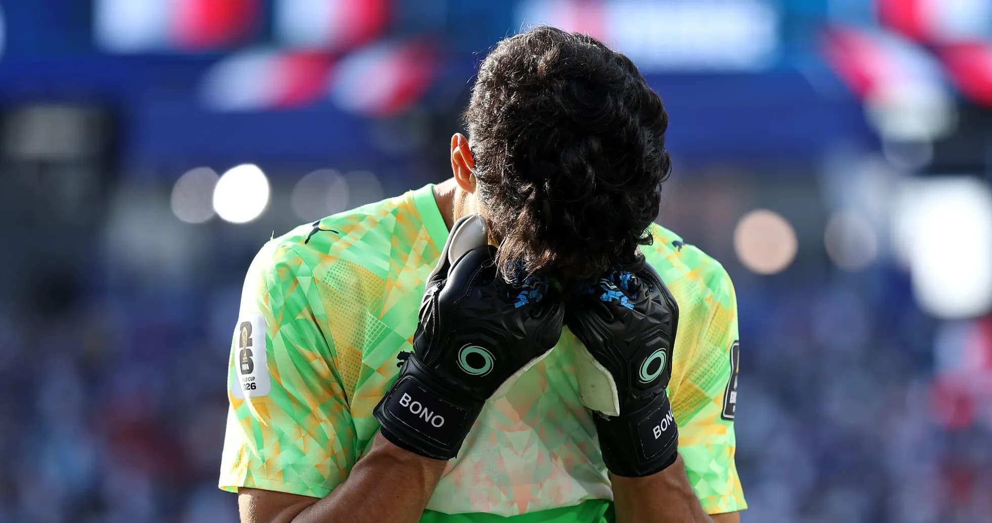 Goalkeeper holding head with gloves during match