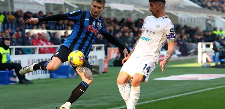 Cagliari player challenging Atalanta opponent for the ball