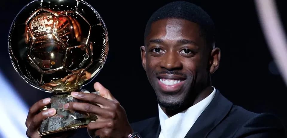 Player holding Ballon d'Or trophy on stage