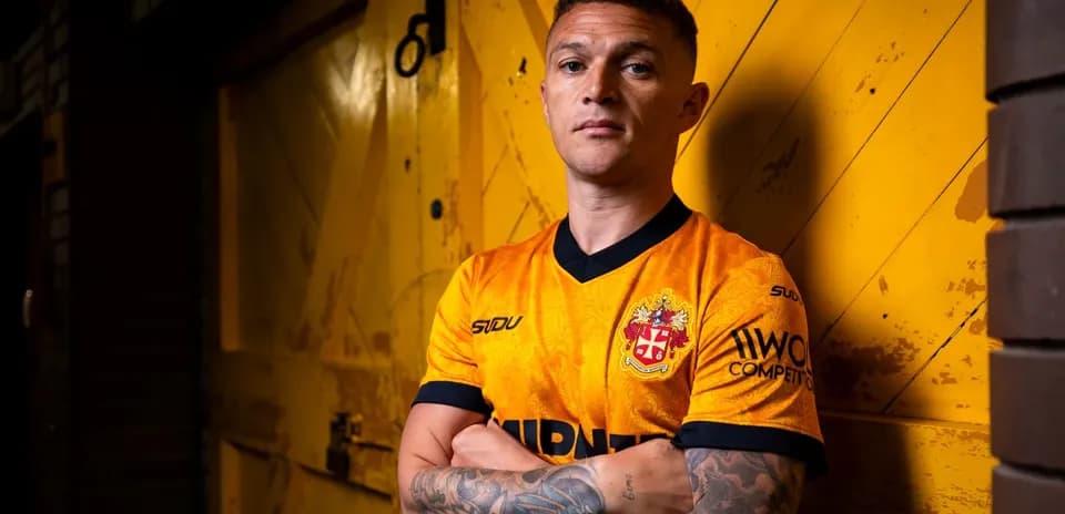 Player posing in orange team jersey against yellow backdrop