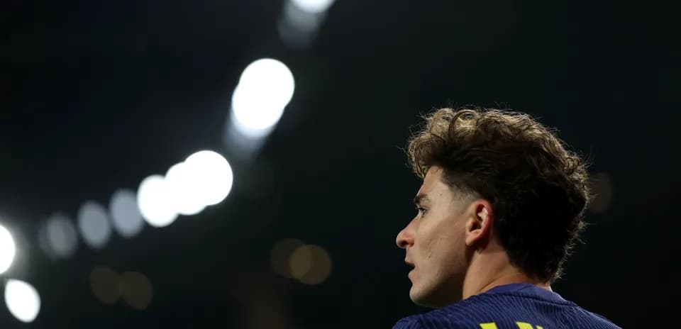 Player with curly hair looking away during match