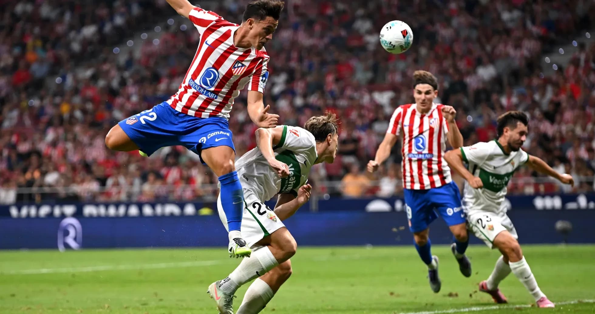 Atletico Madrid player jumping over Elche opponent