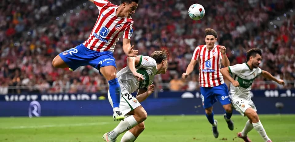 Atletico Madrid player jumping over Elche opponent