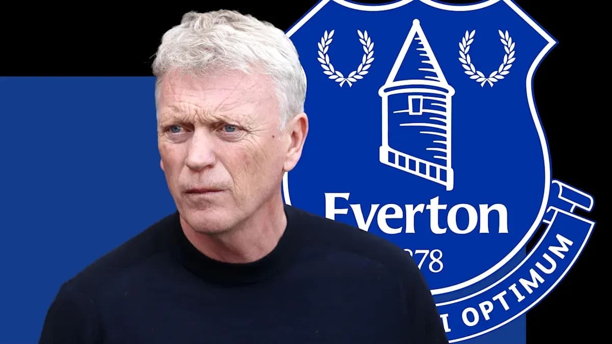Manager in front of Everton club logo background