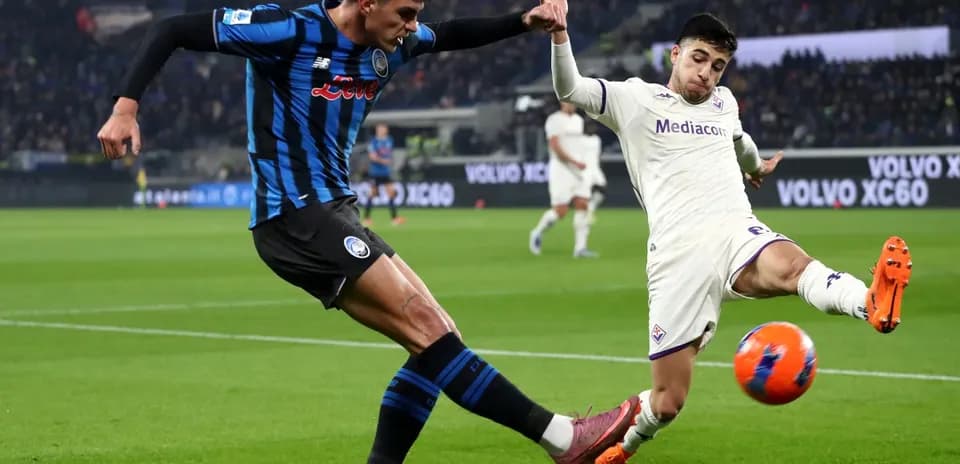 Fiorentina player challenging Atalanta player for ball
