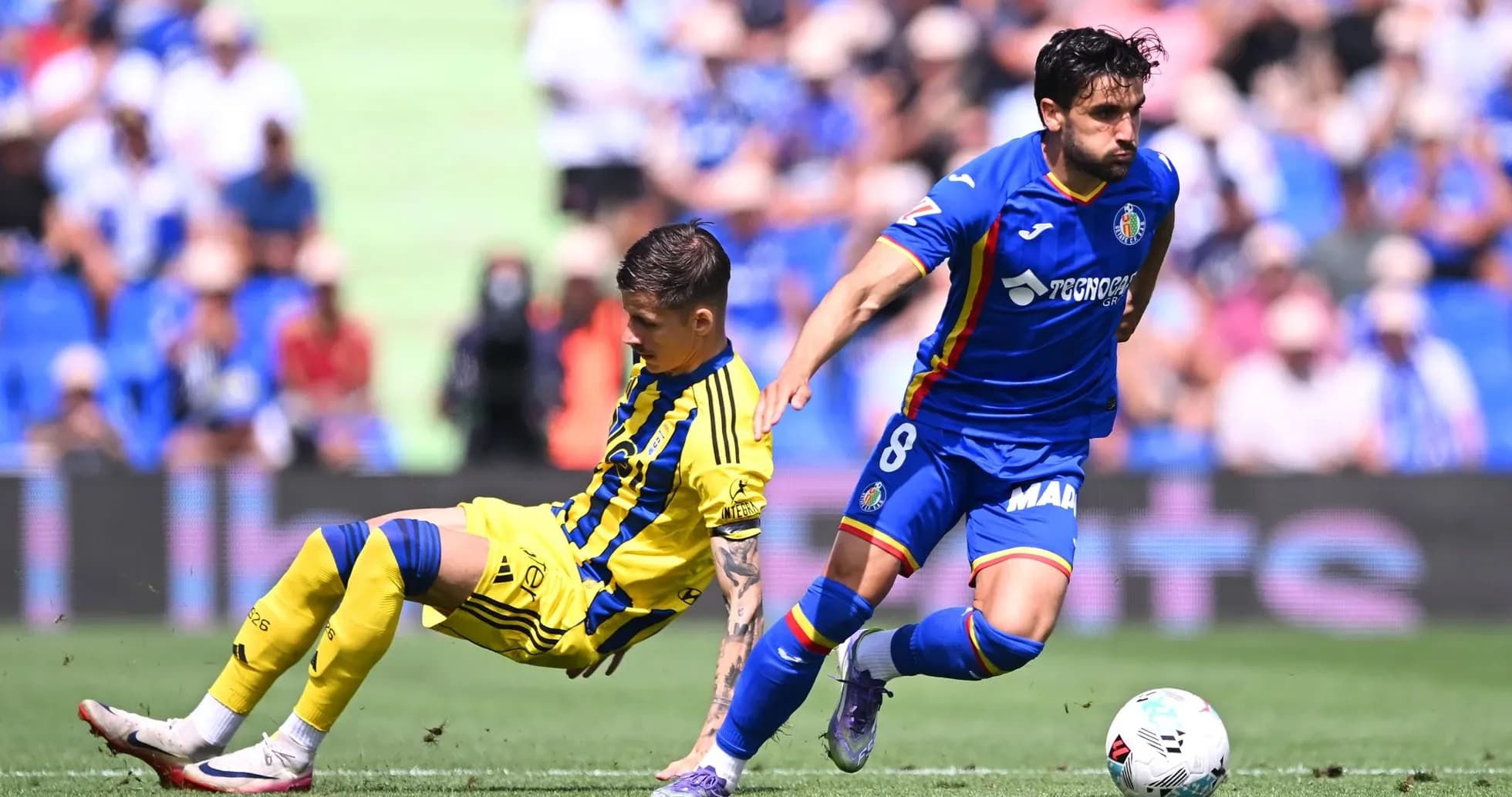 Oviedo player tackles Getafe opponent during match