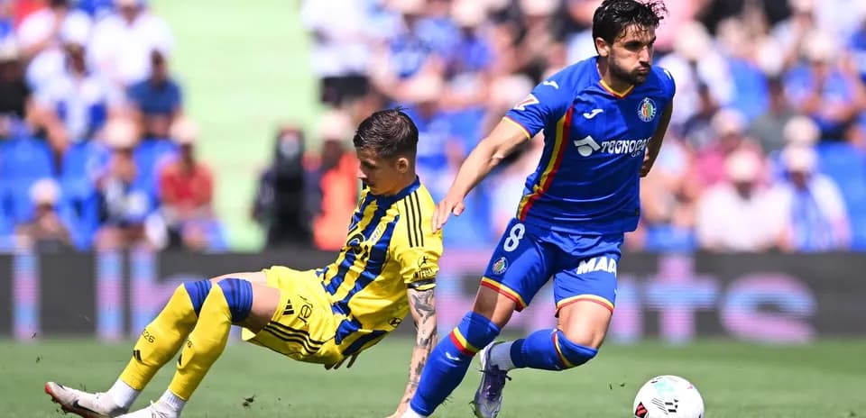 Oviedo player tackles Getafe opponent during match