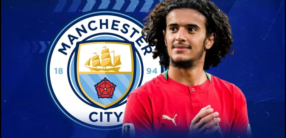 Player in red jersey with Manchester City logo background
