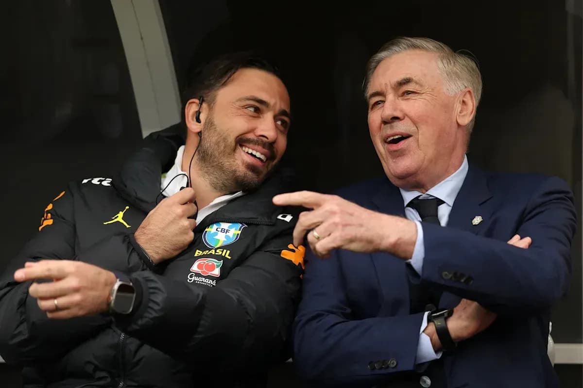 Two coaches laughing in a sports bench area