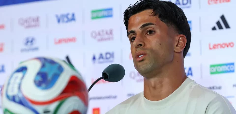 Player speaking at press conference with football in view