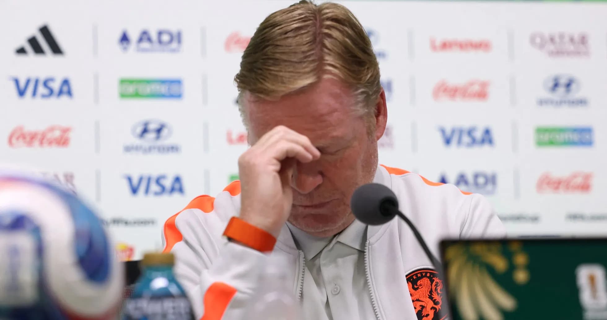 Coach at press conference with hand on forehead Coach at press conference with hand on forehead