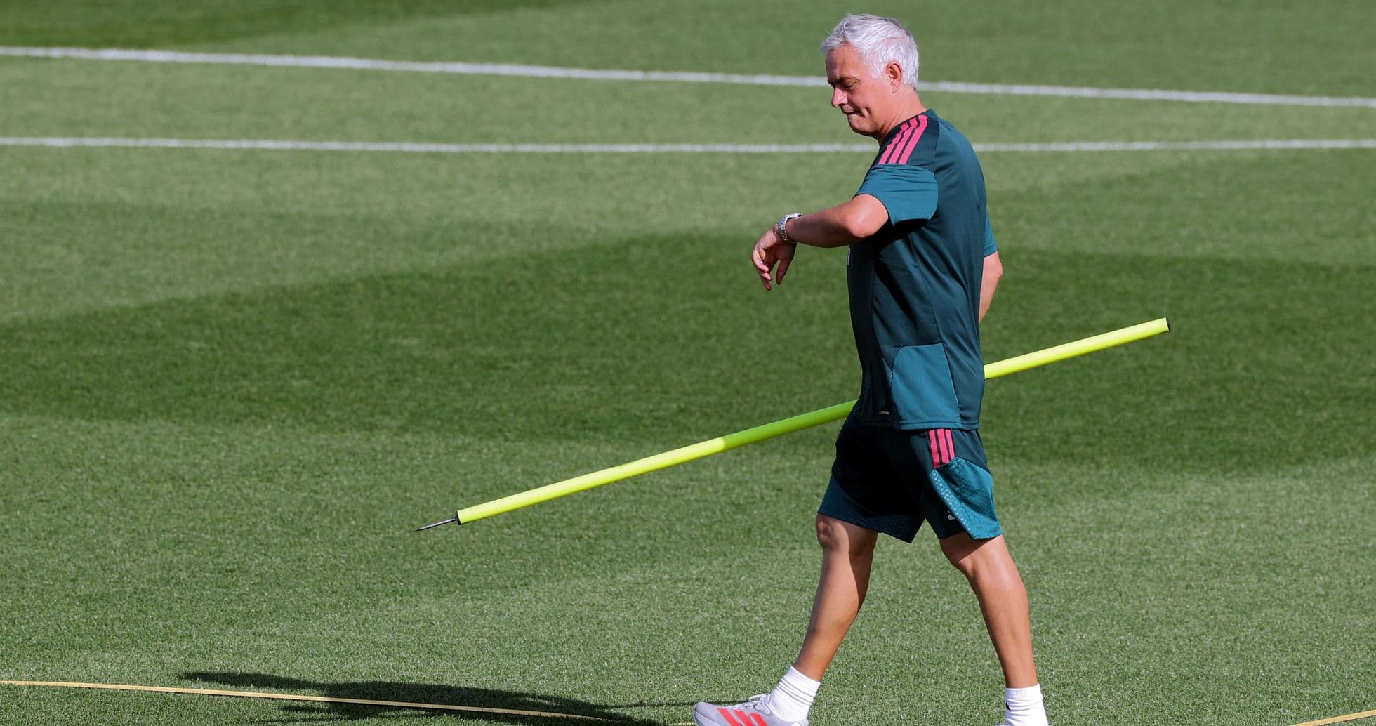 Coach walking on pitch with training equipment Coach walking on pitch with training equipment
