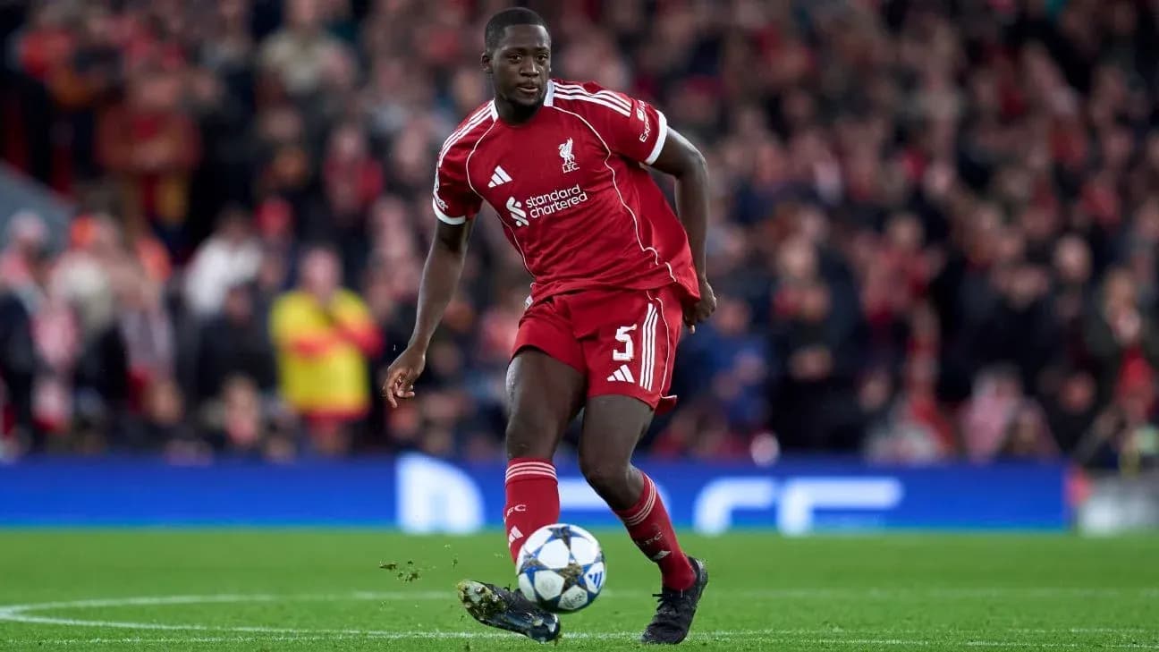 Player in Liverpool kit dribbling ball on pitch Player in Liverpool kit dribbling ball on pitch