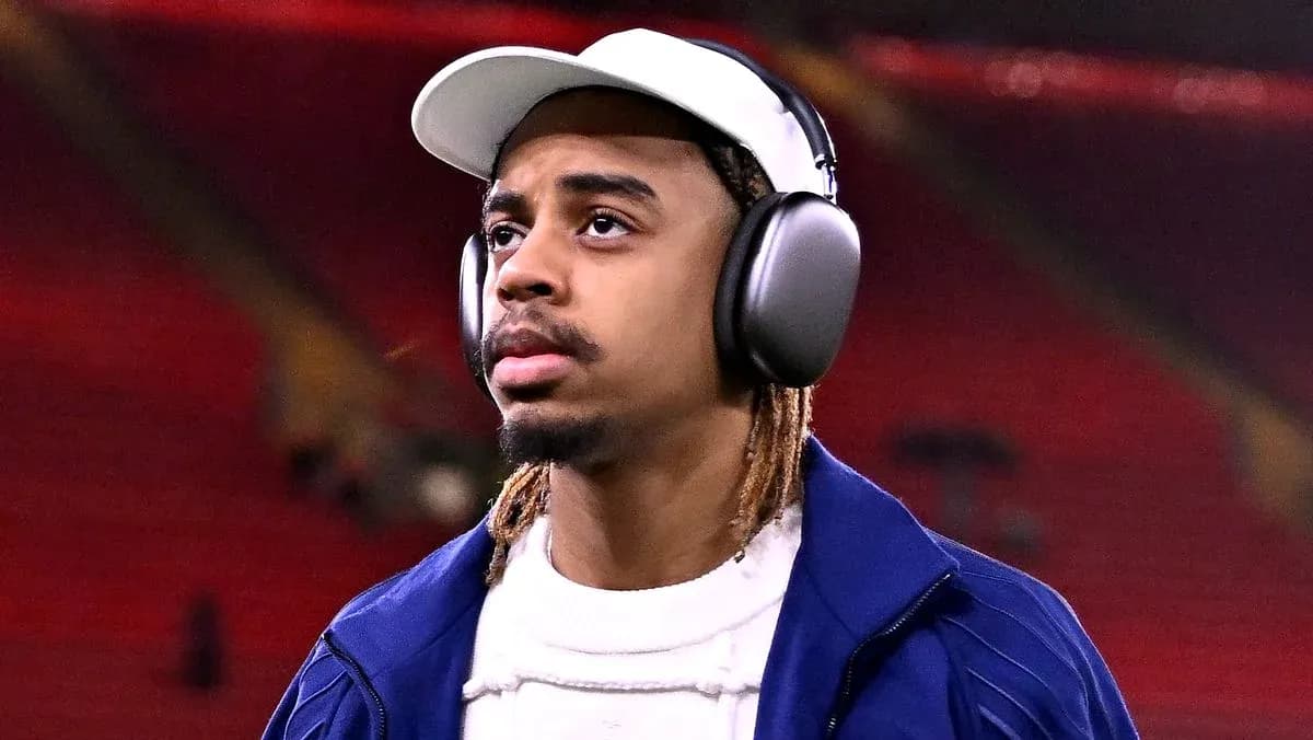 Player wearing headphones walking on stadium field Player wearing headphones walking on stadium field