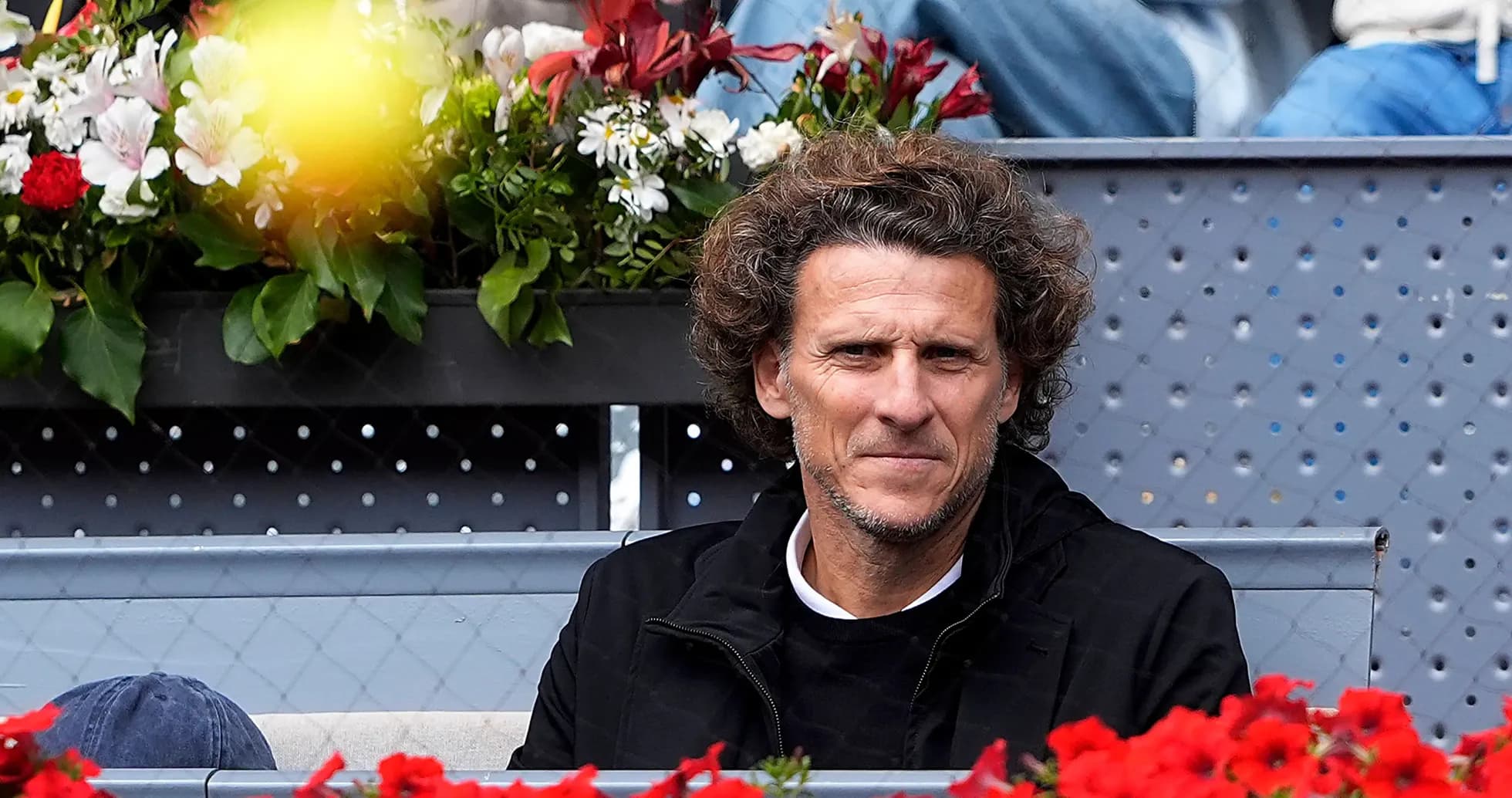 Man sitting among flowers at tennis event Man sitting among flowers at tennis event