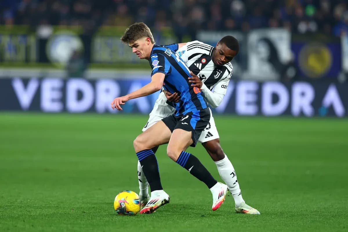 Juventus player tackling Atalanta opponent during match Juventus player tackling Atalanta opponent during match