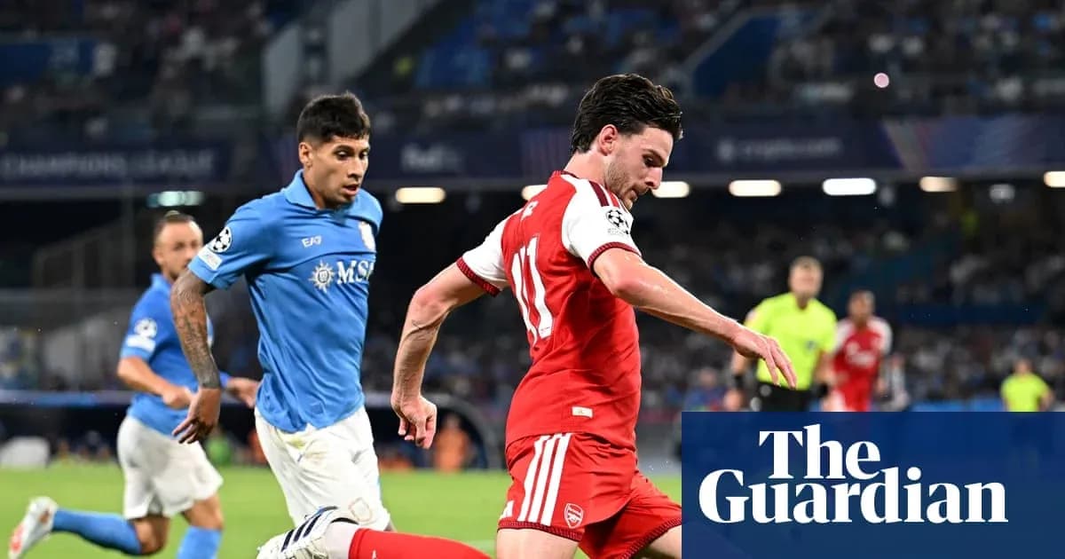 Player in red dribbling past opponent in blue jersey Player in red dribbling past opponent in blue jersey