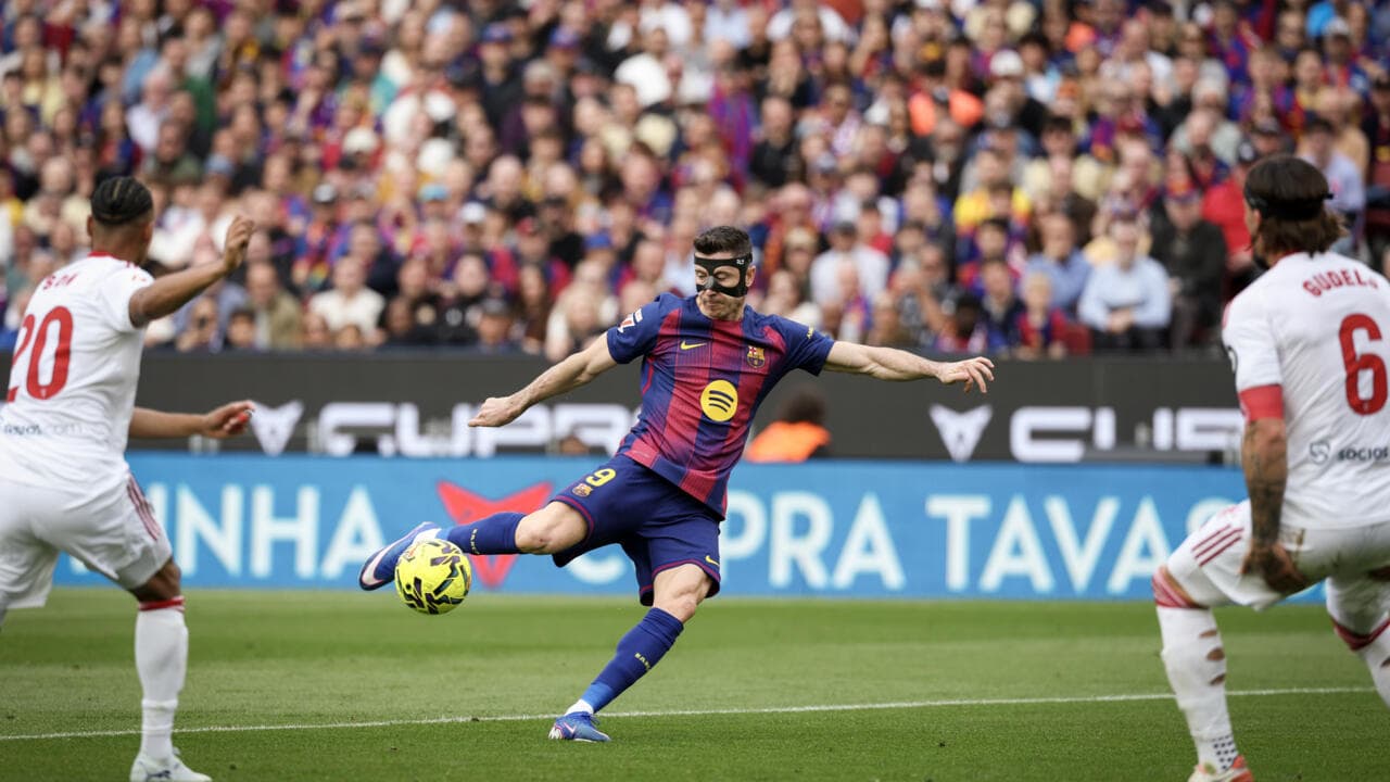 Player in mask striking the ball during match Player in mask striking the ball during match