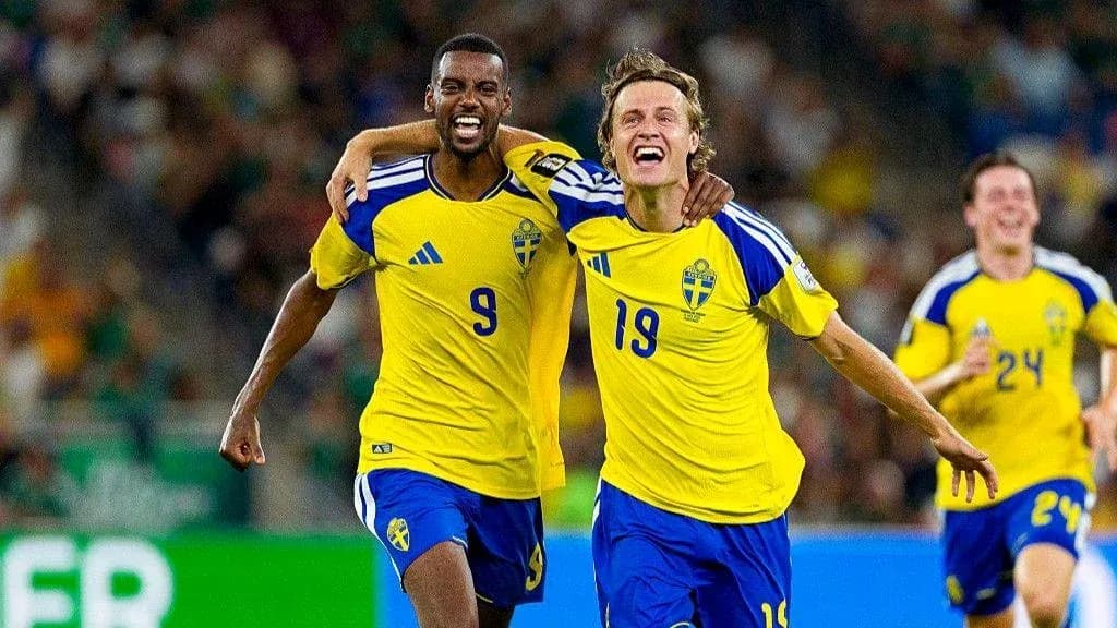 Two Swedish players celebrating a goal on field Two Swedish players celebrating a goal on field