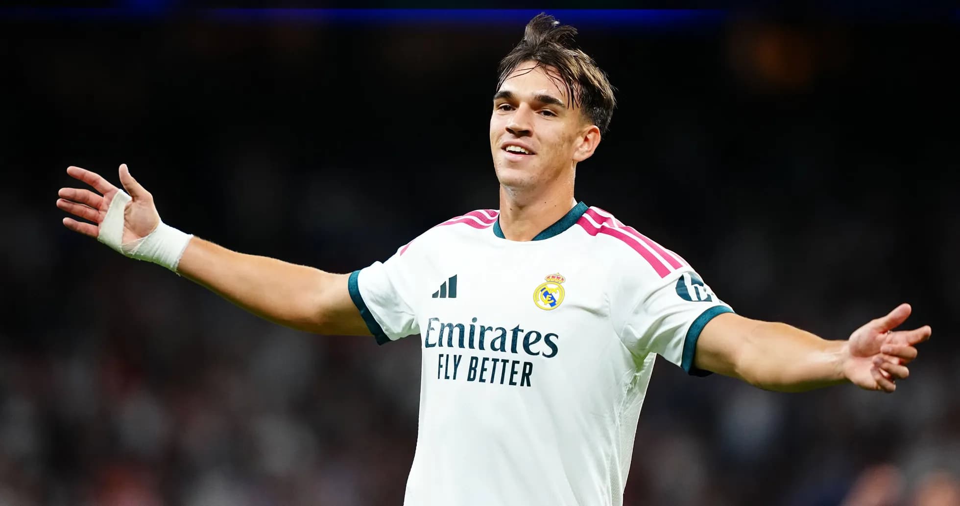 Player celebrating in Real Madrid jersey on pitch Player celebrating in Real Madrid jersey on pitch