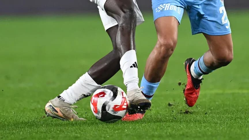 Two players contesting for the ball on field Two players contesting for the ball on field