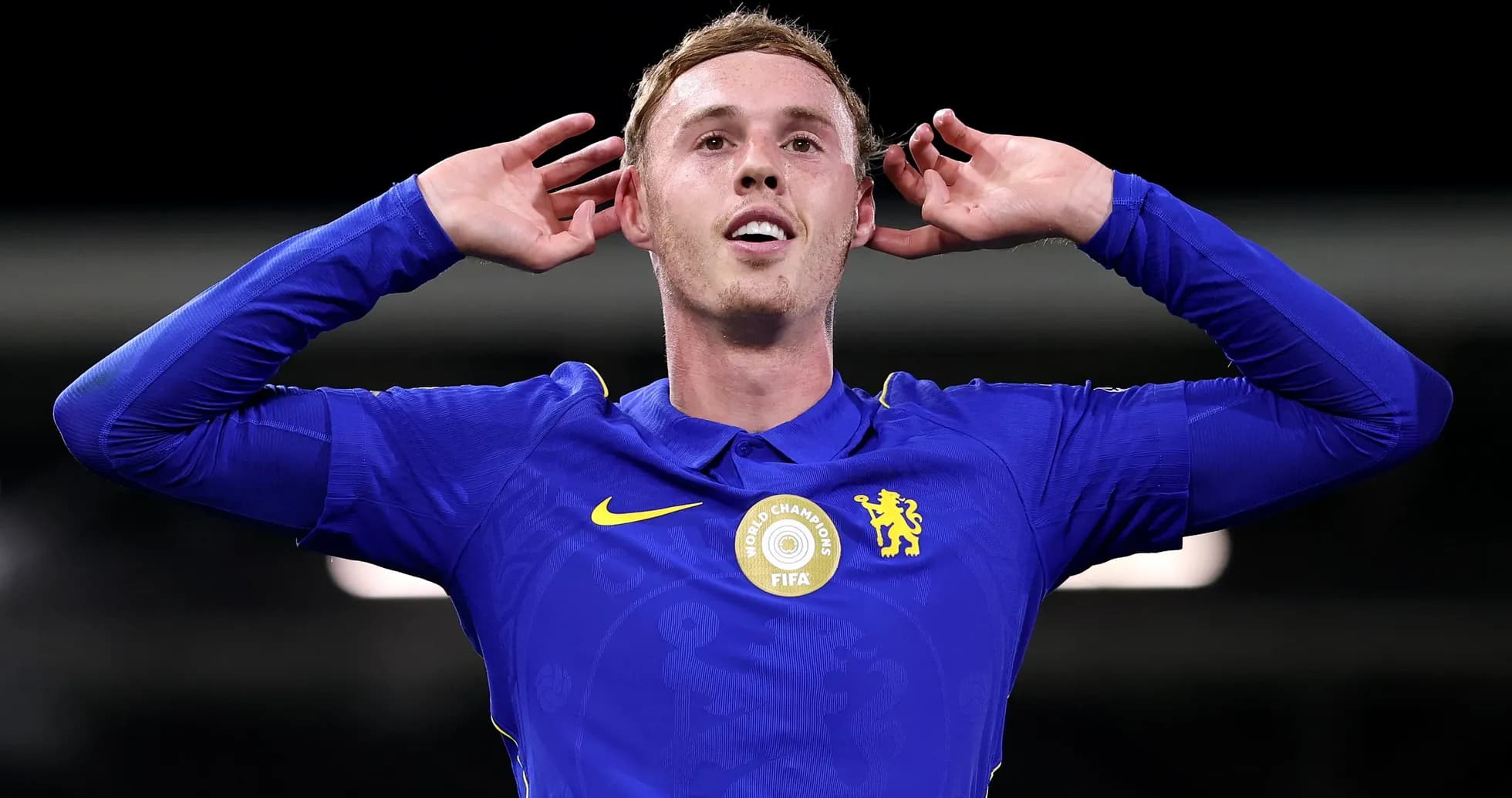 Player celebrating in Chelsea's blue kit with hands raised Player celebrating in Chelsea's blue kit with hands raised