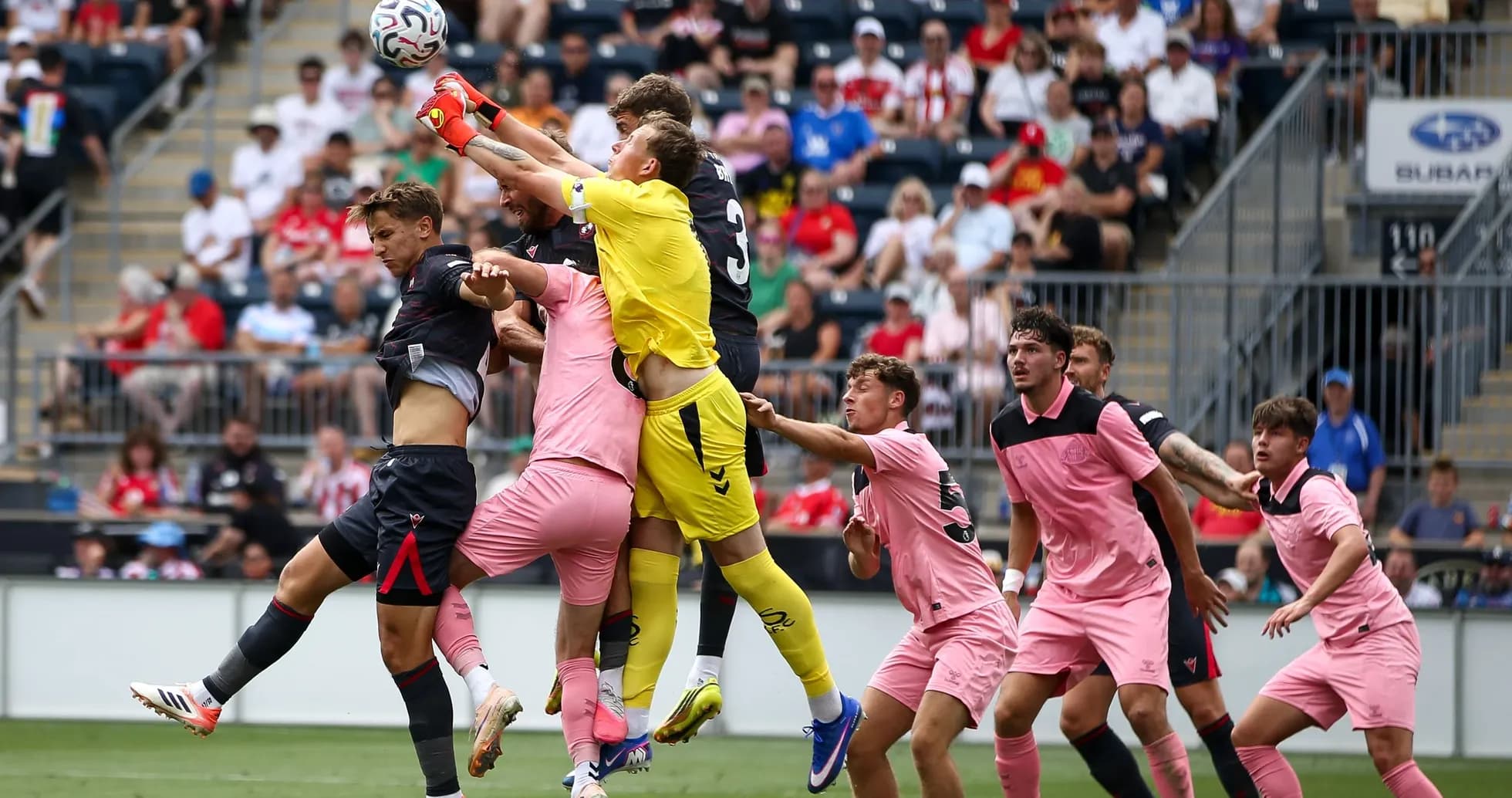 Goalkeeper jumping to catch the ball amid players Goalkeeper jumping to catch the ball amid players
