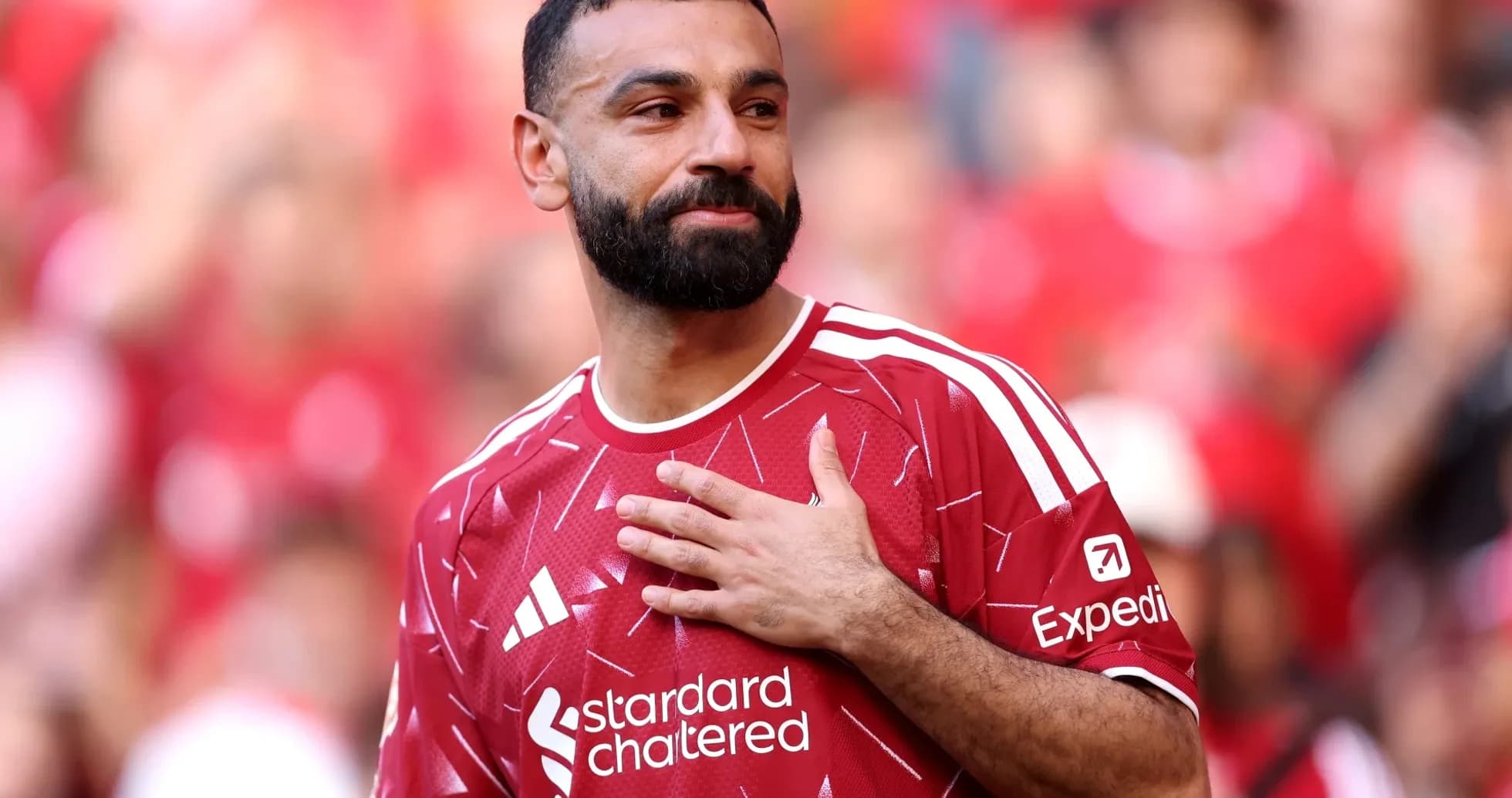 Player in red jersey gestures to crowd at stadium Player in red jersey gestures to crowd at stadium