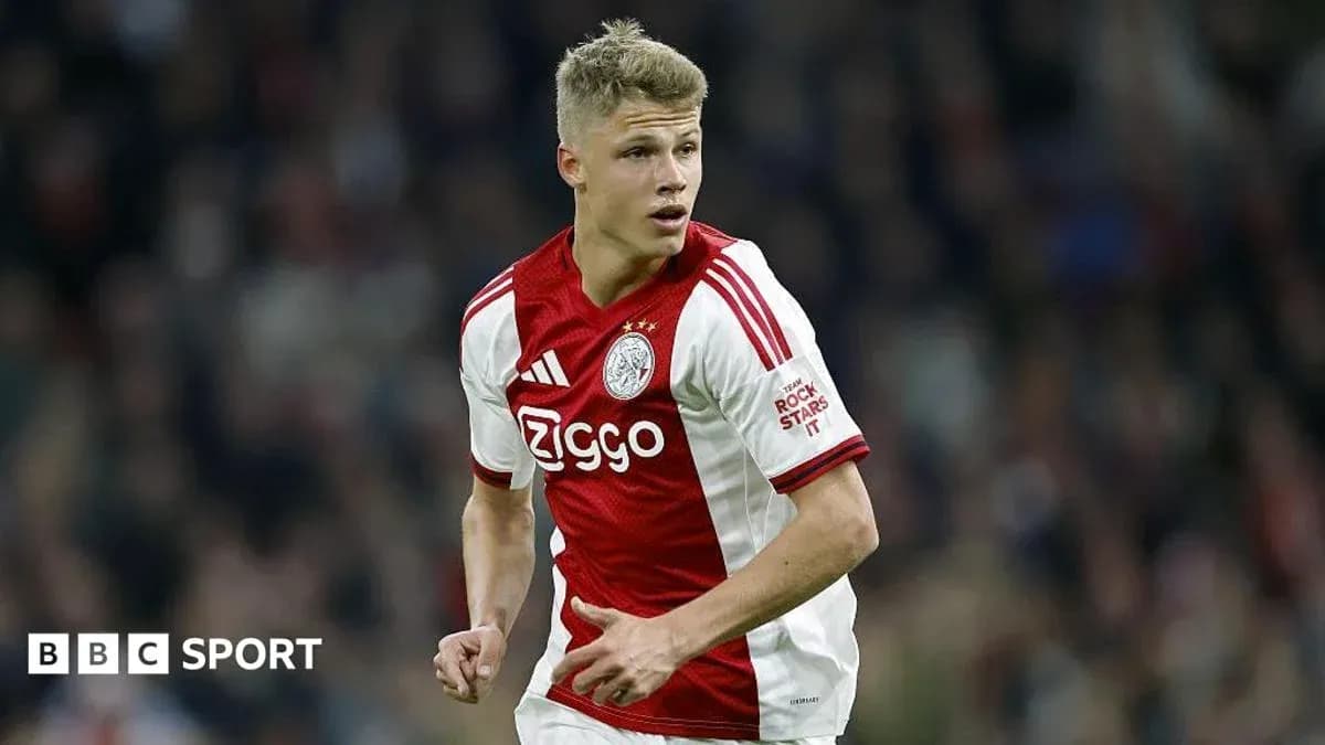 Player in Ajax kit running during a match Player in Ajax kit running during a match