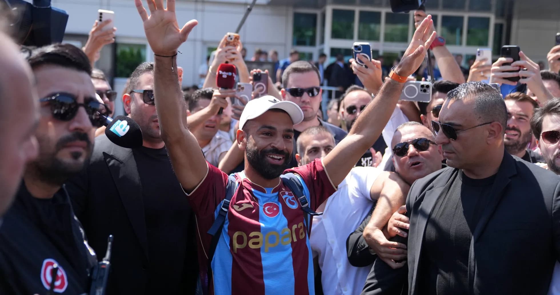 Player greeting fans while surrounded by supporters Player greeting fans while surrounded by supporters