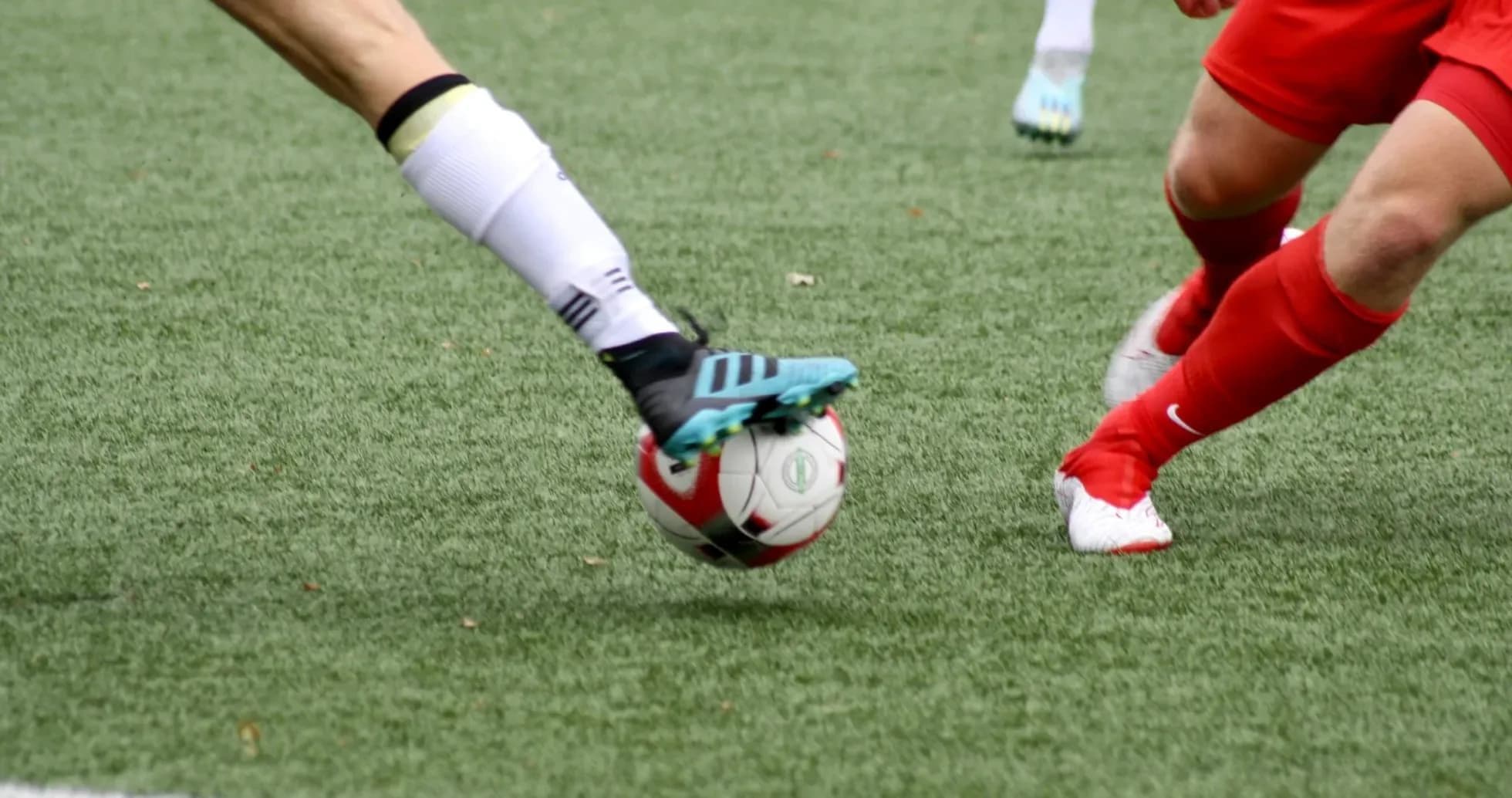 Players challenging for the ball in football match Players challenging for the ball in football match