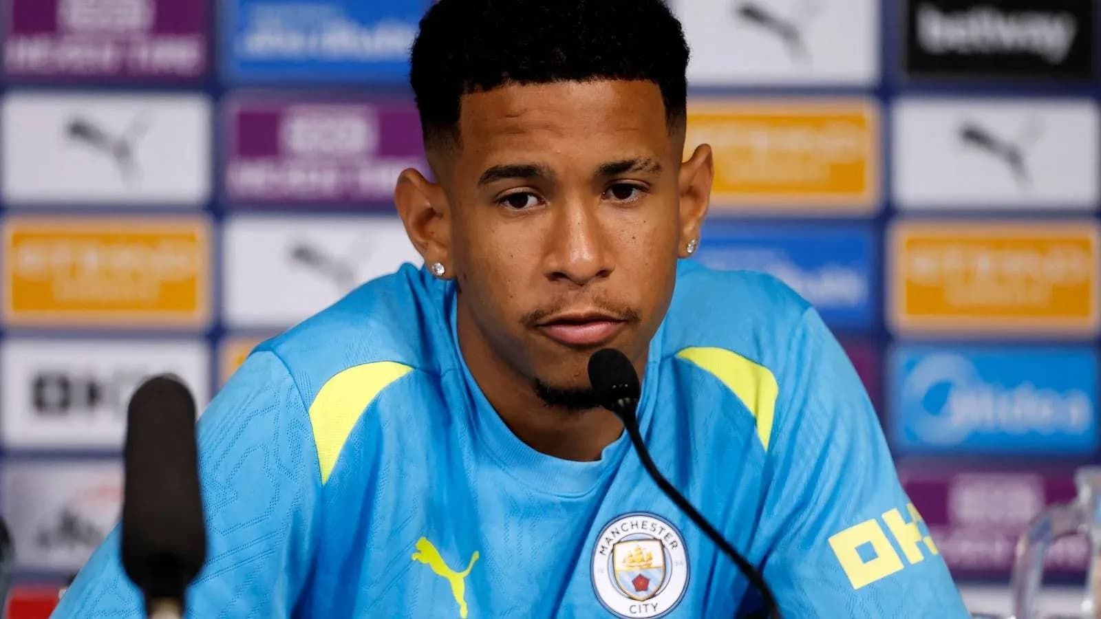 Player at press conference wearing Manchester City kit Player at press conference wearing Manchester City kit