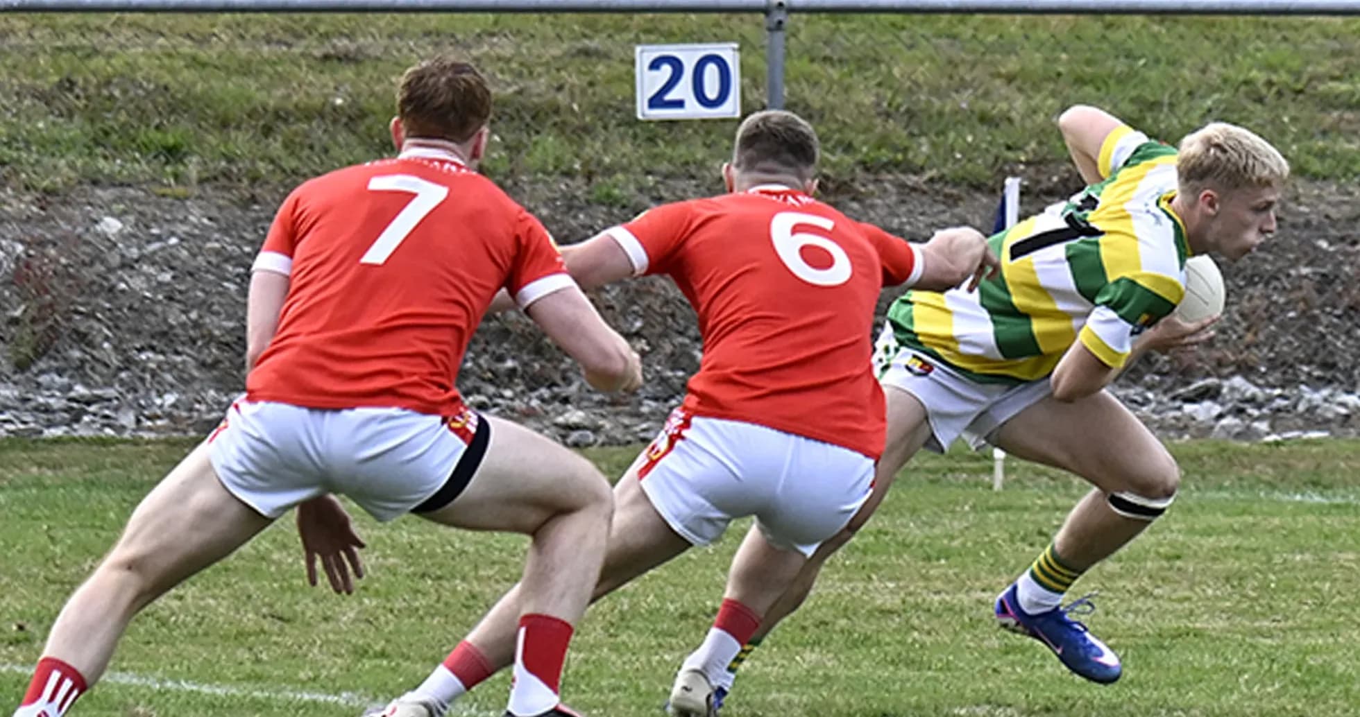 Player in green shirt evading two defenders in rugby Player in green shirt evading two defenders in rugby