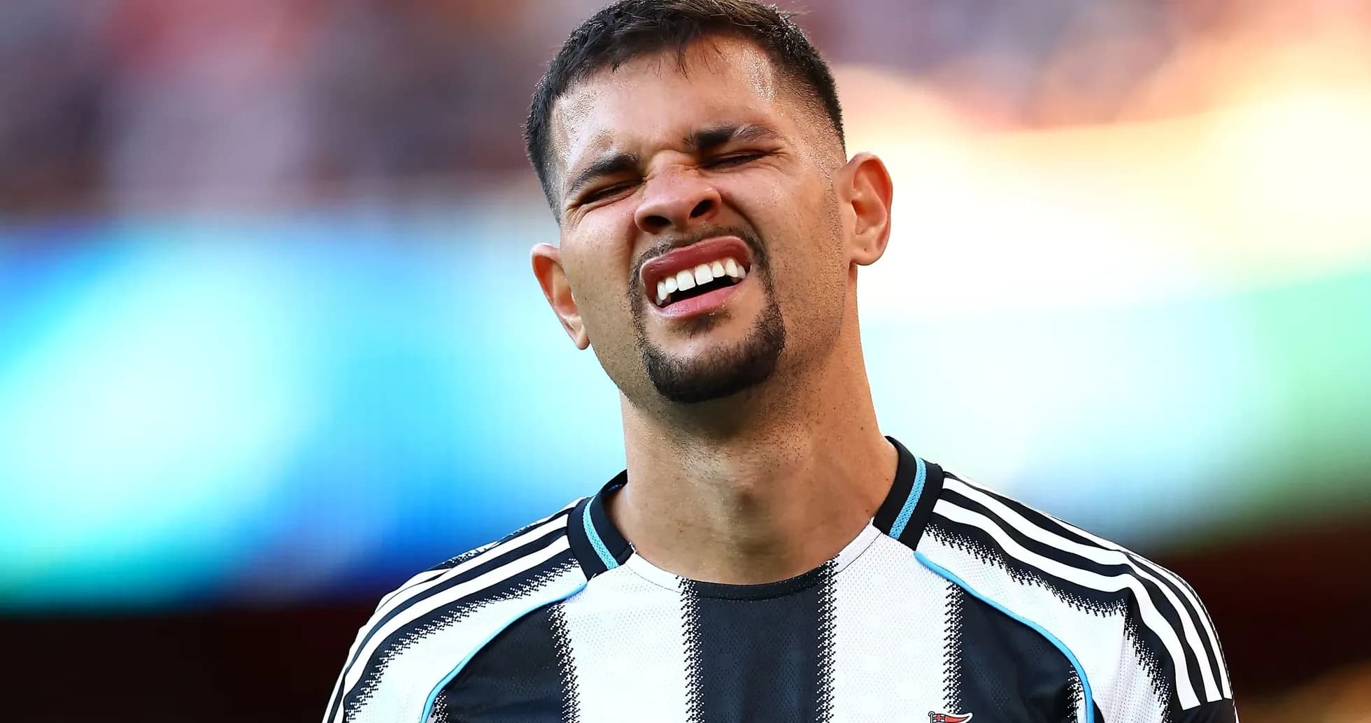 Player grimacing during a match in black and white kit Player grimacing during a match in black and white kit