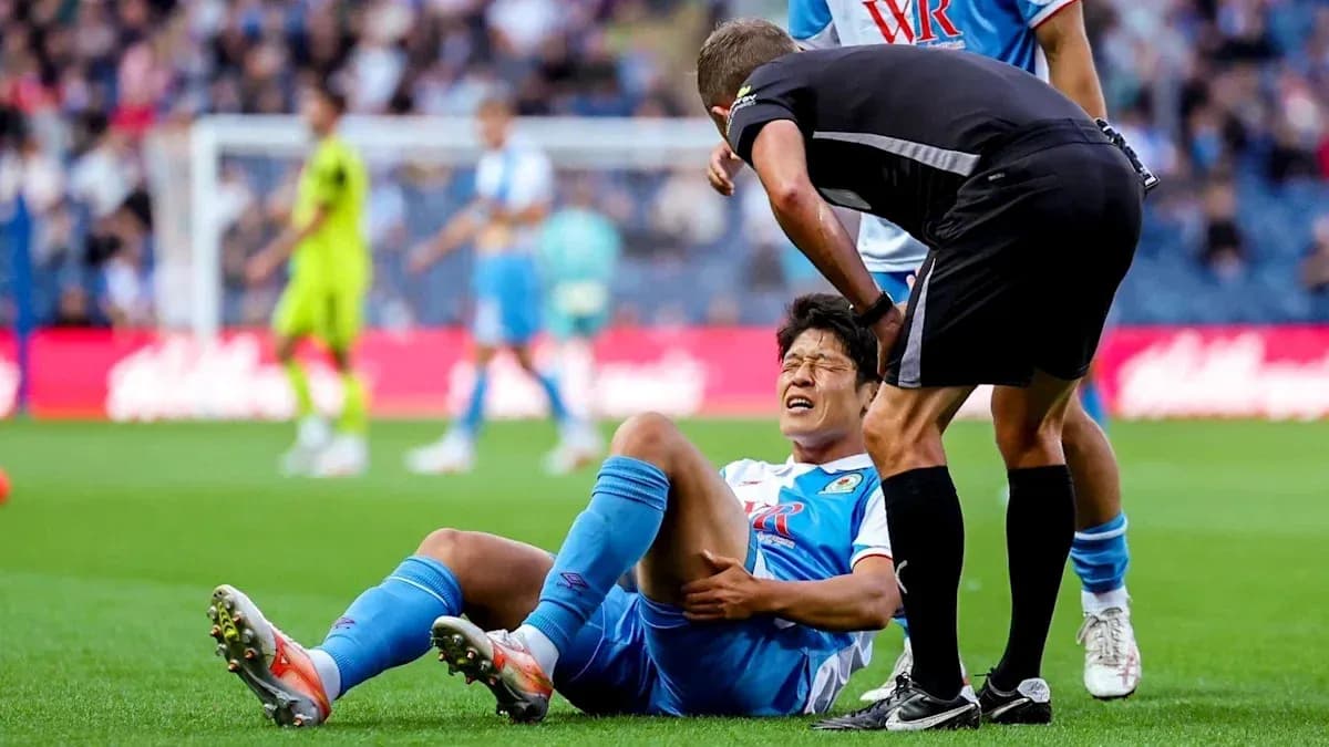 Player on the ground with referee checking injury Player on the ground with referee checking injury