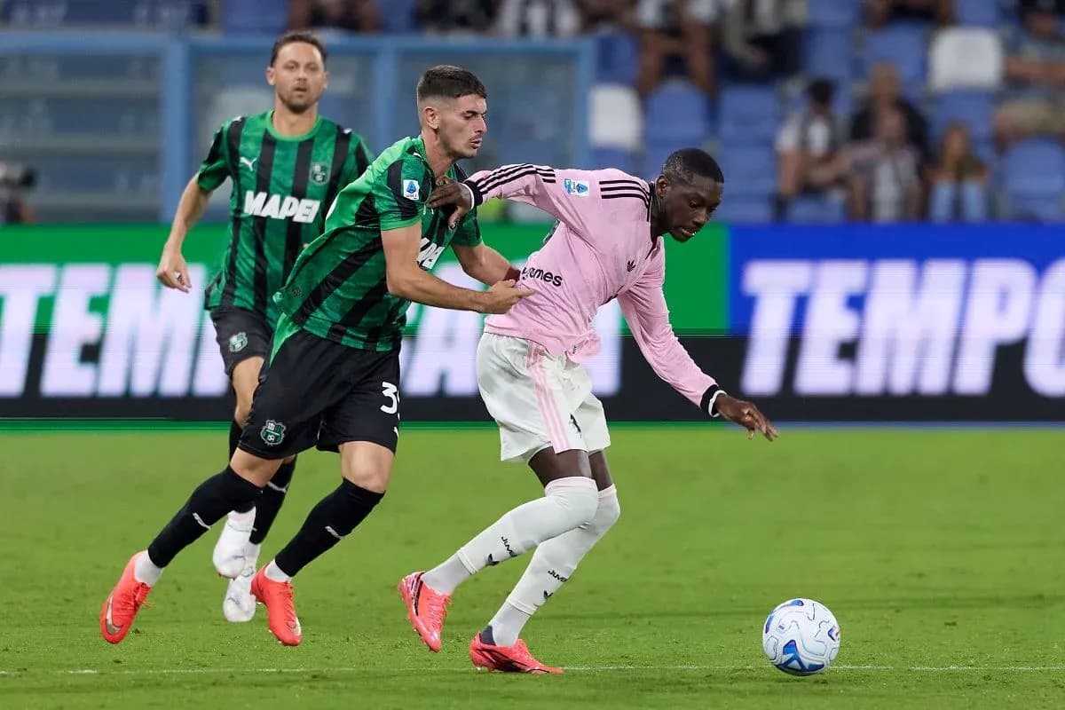 Sassuolo player challenges Juventus opponent for the ball Sassuolo player challenges Juventus opponent for the ball