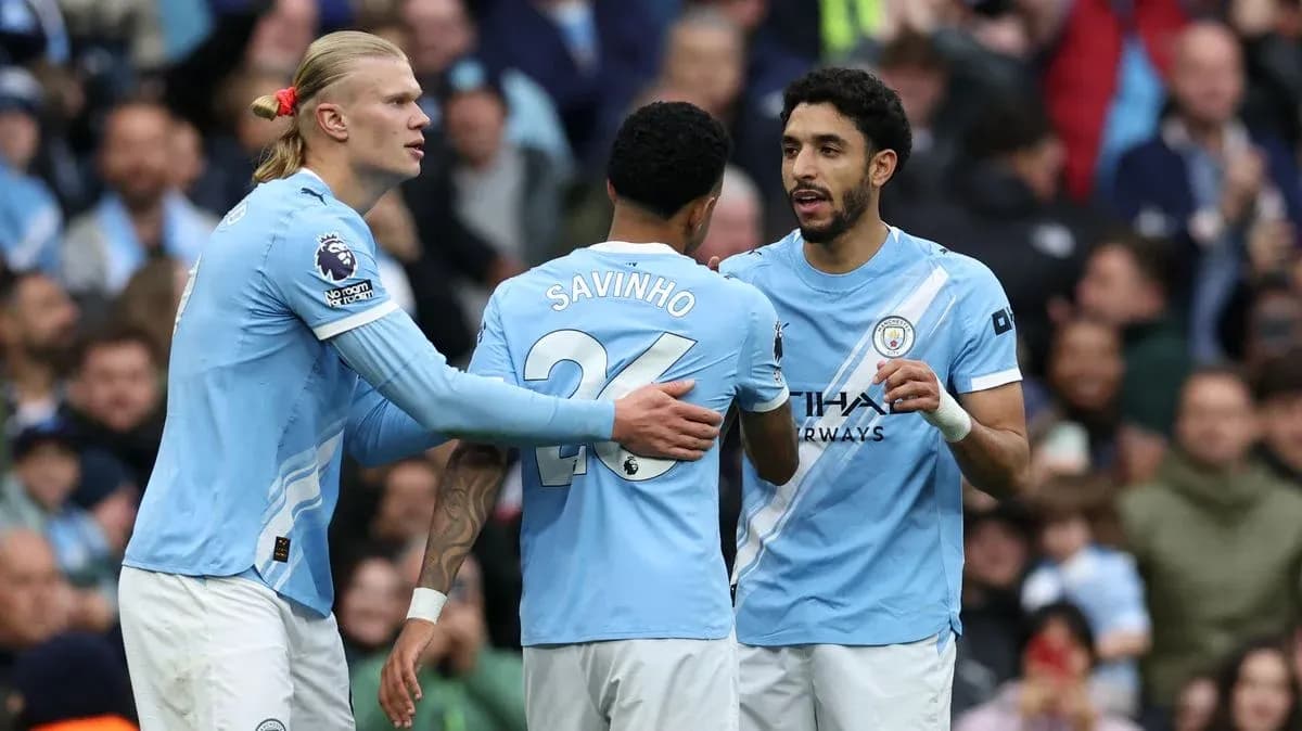 Three Manchester City players discussing on the field Three Manchester City players discussing on the field