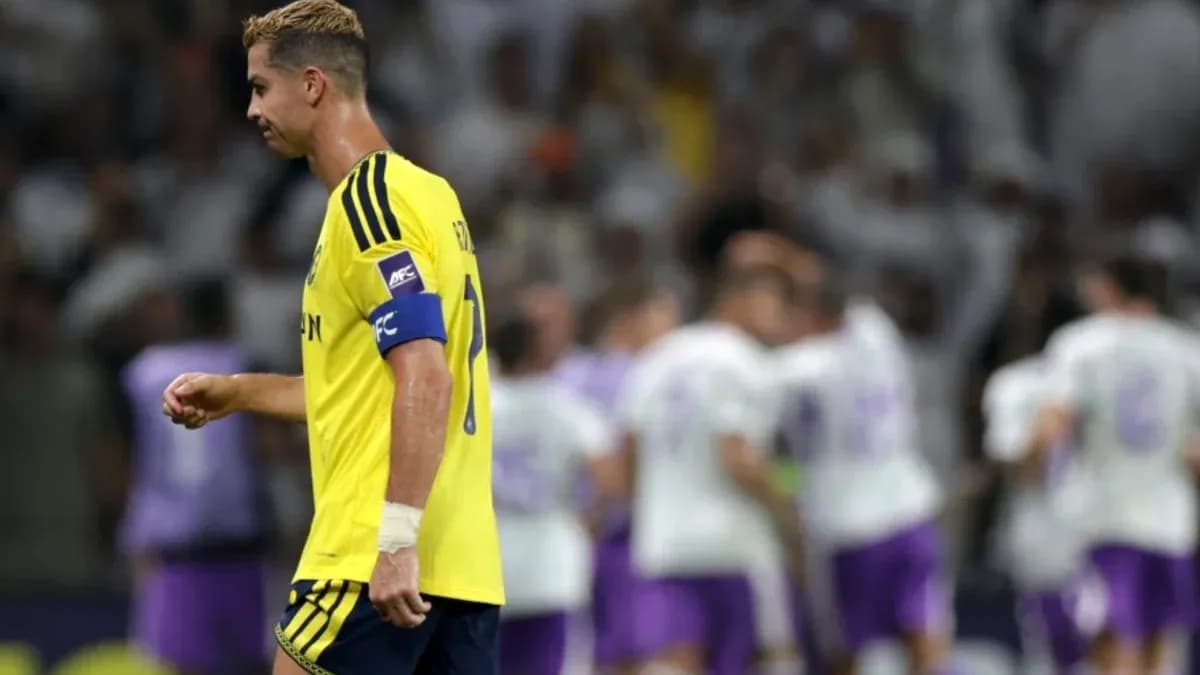 Player walking past celebrating teammates after match Player walking past celebrating teammates after match