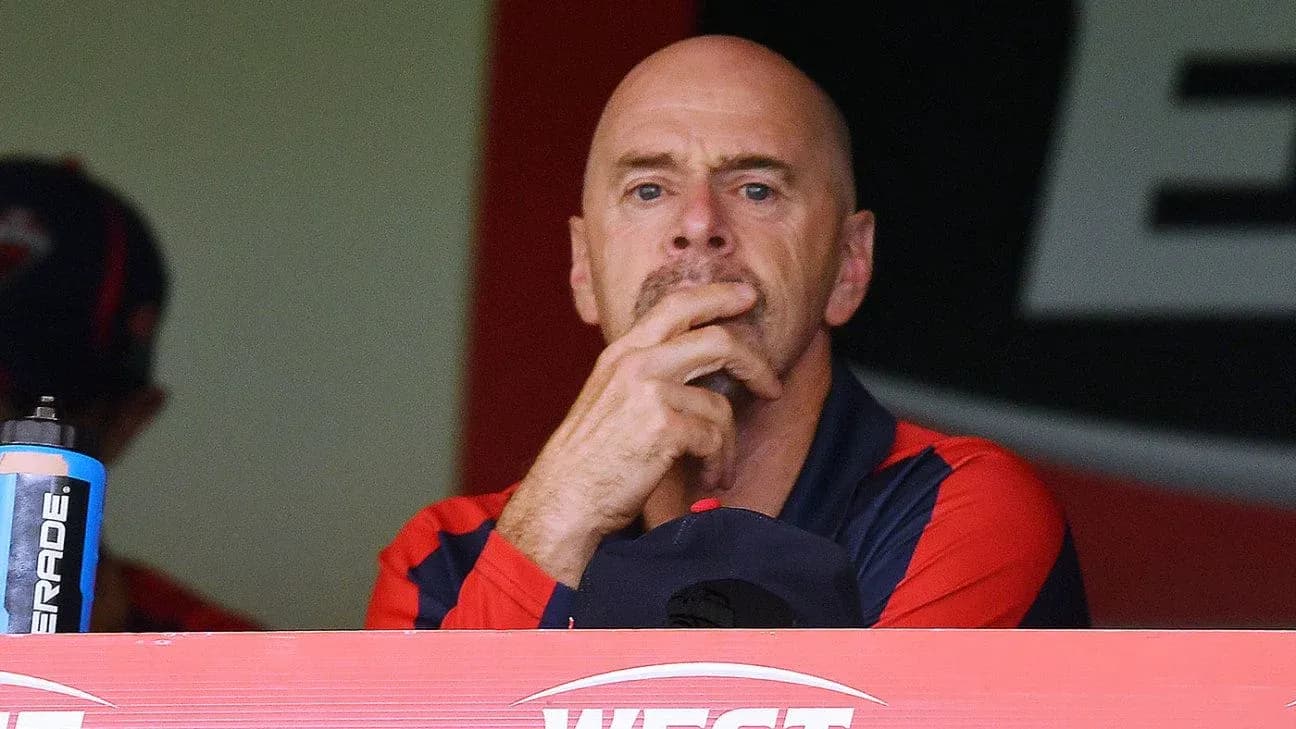 Coach observing the game from the dugout Coach observing the game from the dugout