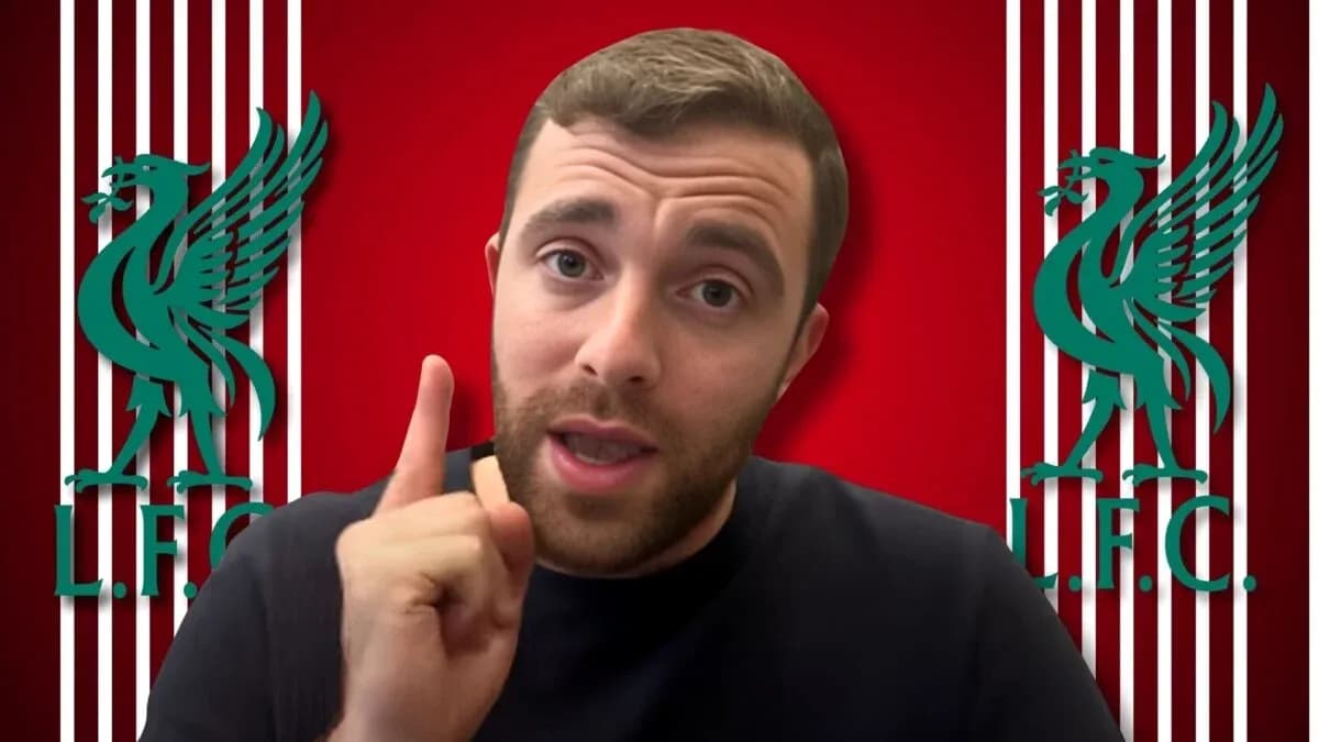 Person speaking in front of Liverpool FC logo Person speaking in front of Liverpool FC logo