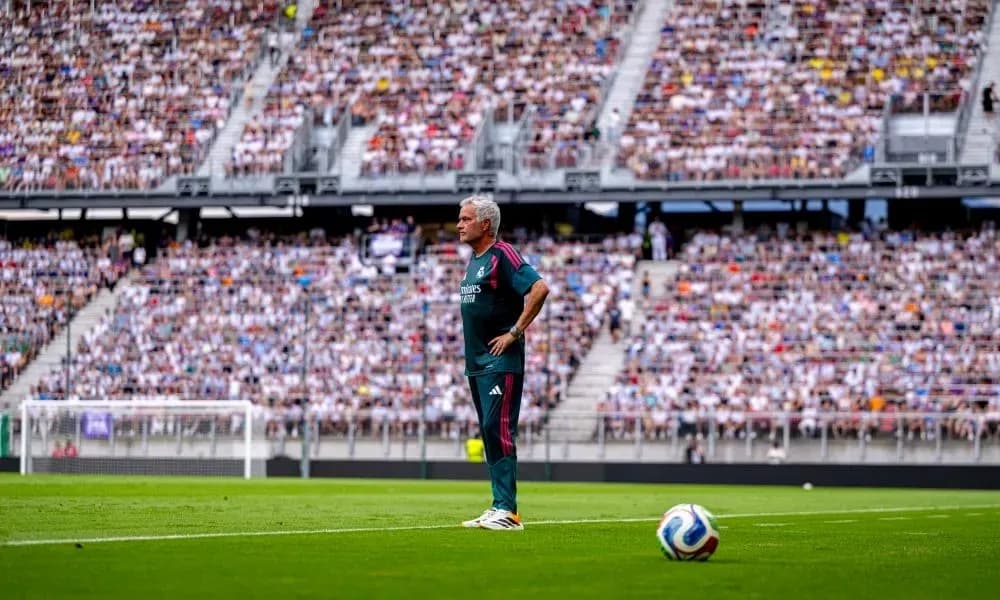 Coach observing the game with packed stadium behind Coach observing the game with packed stadium behind