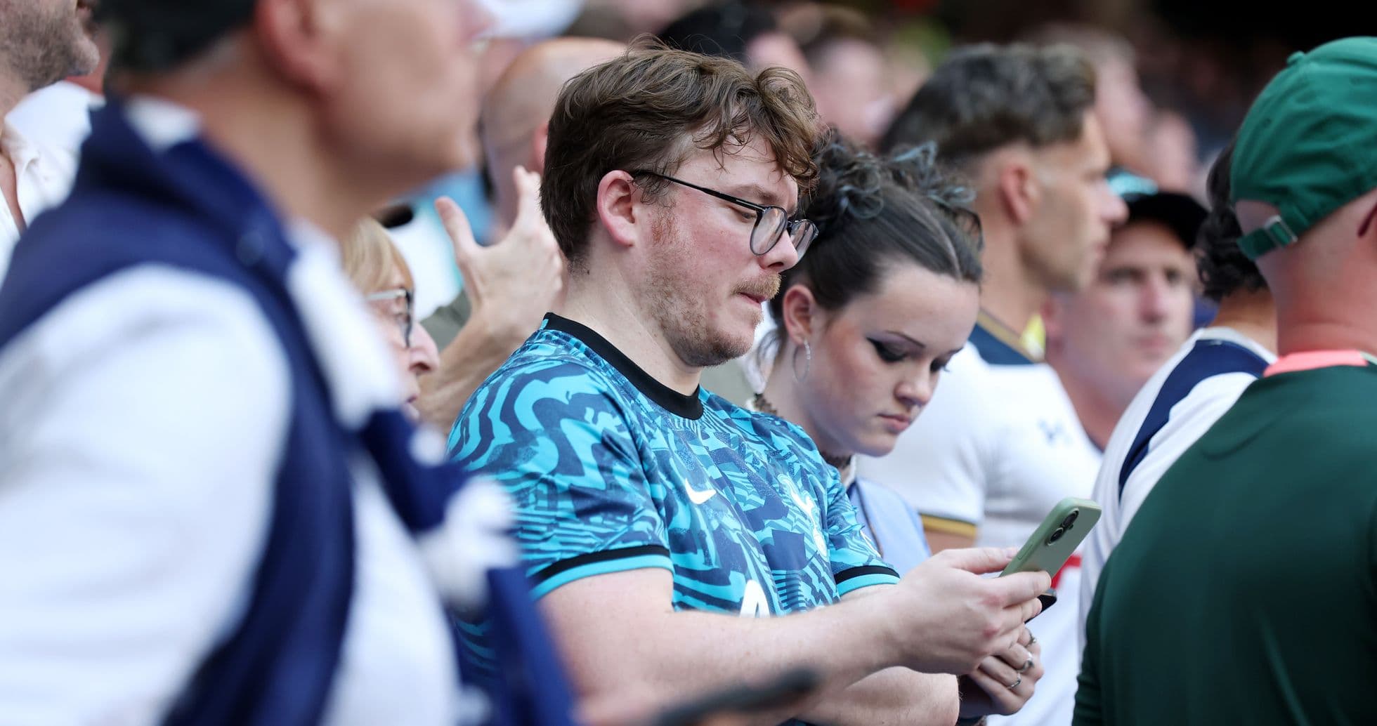 Fans watching the match, some using mobile phones Fans watching the match, some using mobile phones