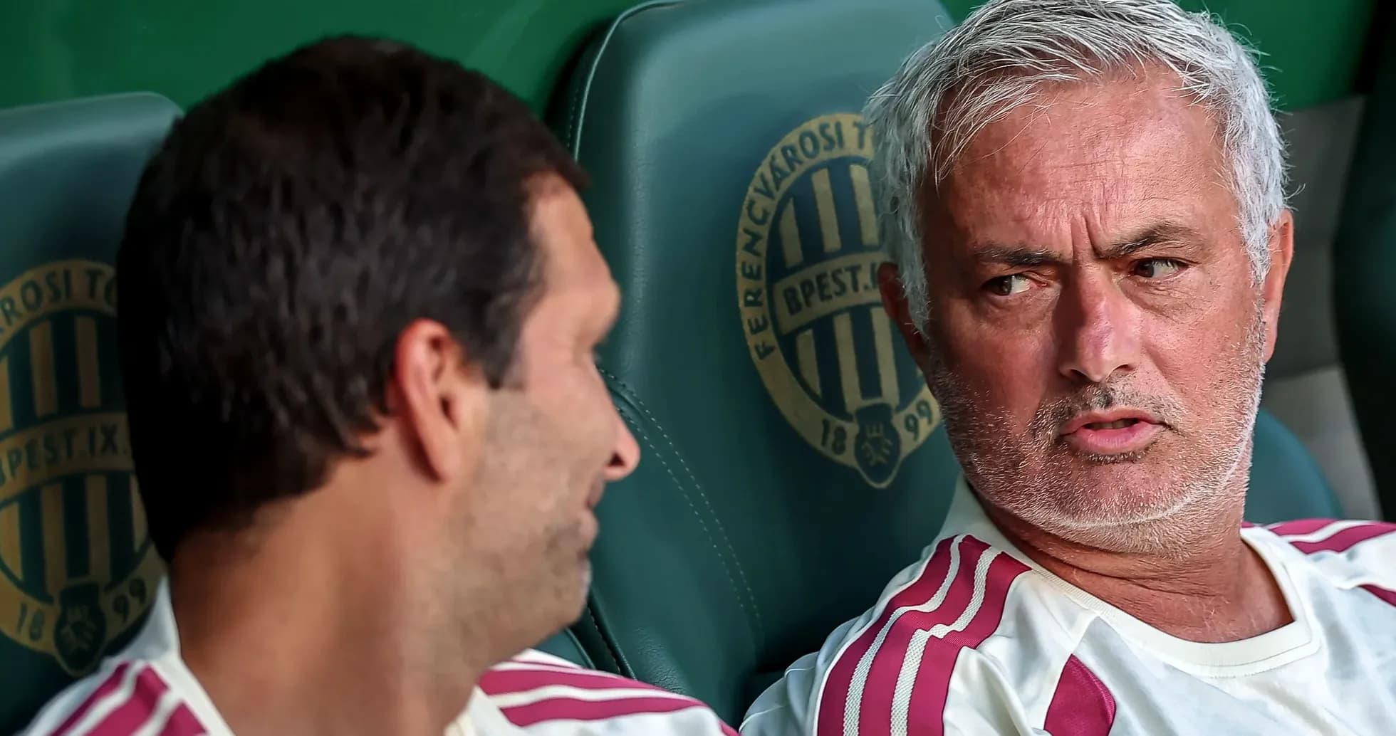 Two coaches discussing on the bench during match Two coaches discussing on the bench during match