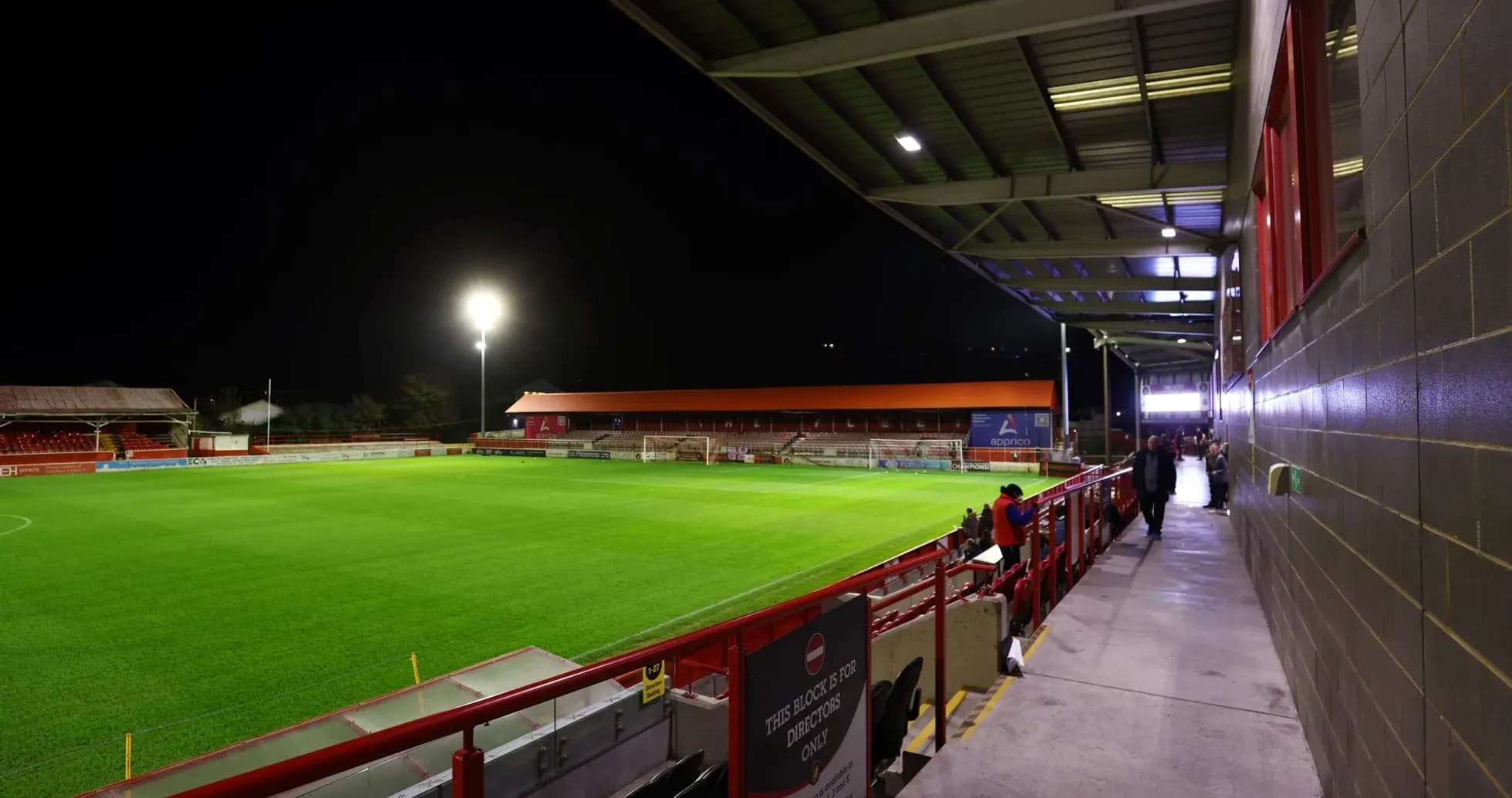 Empty football stadium at night with illuminated pitch Empty football stadium at night with illuminated pitch